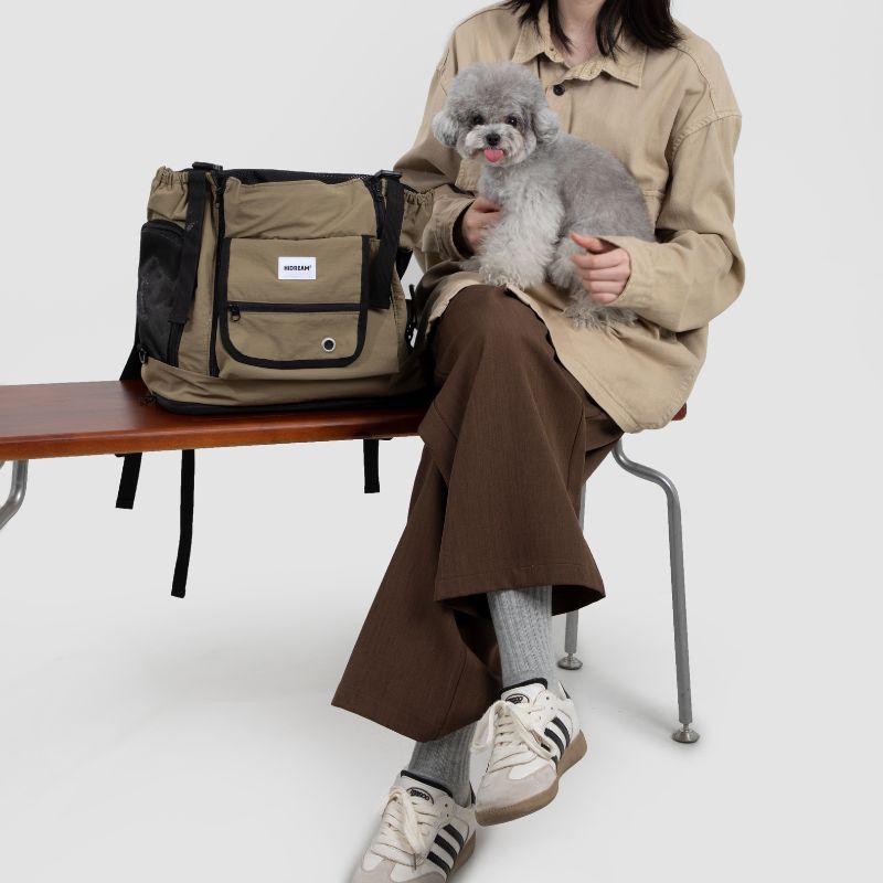 UrbanTrail multifunctional pet front carrier bag displayed with owner holding small dog on bench