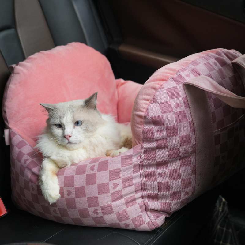 Pink tartan pet car seat with heart patterns, comfortable for cats during car rides.