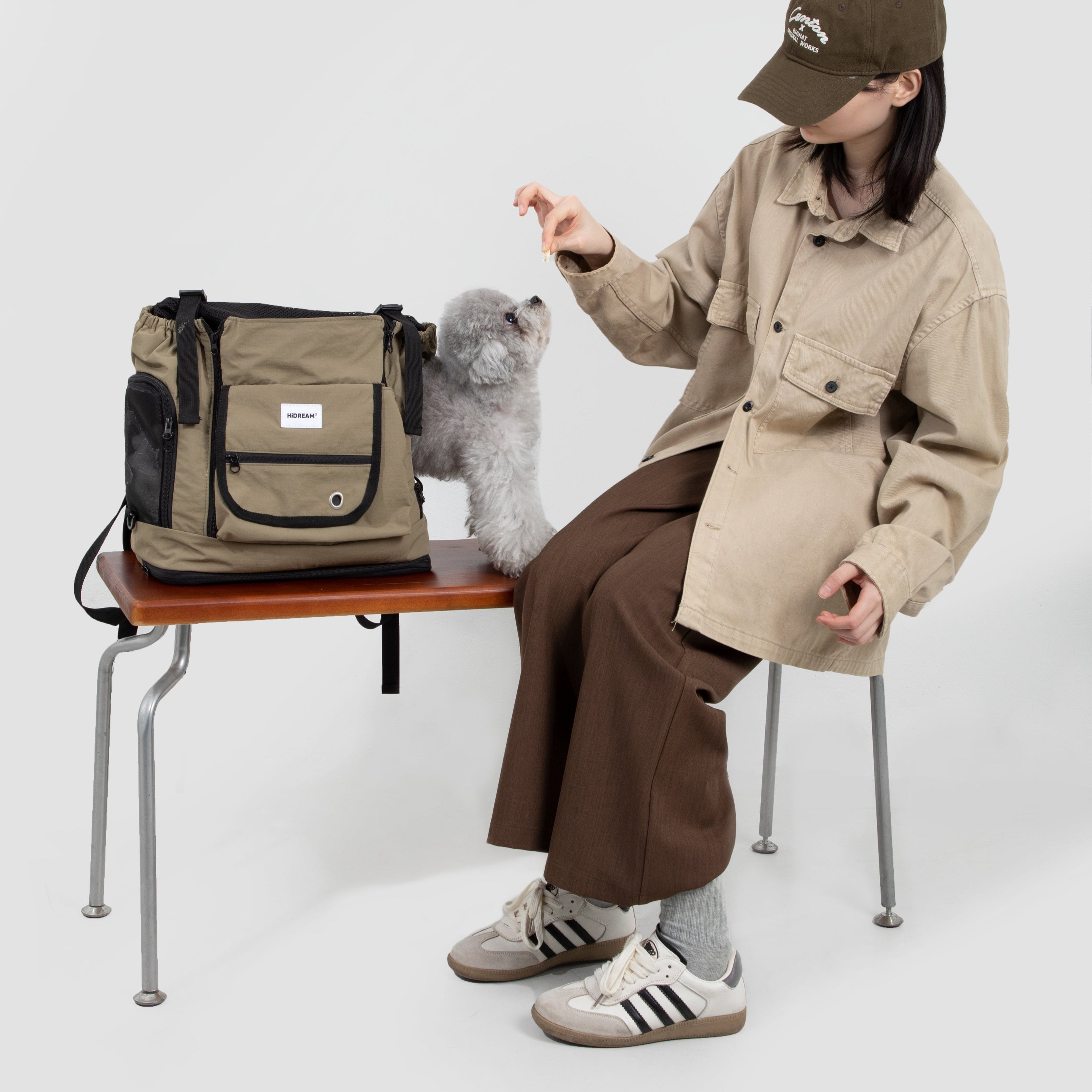 UrbanTrail Multifunctional Pet Front Carrier Bag - Beige dog carrier with small gray poodle on bench